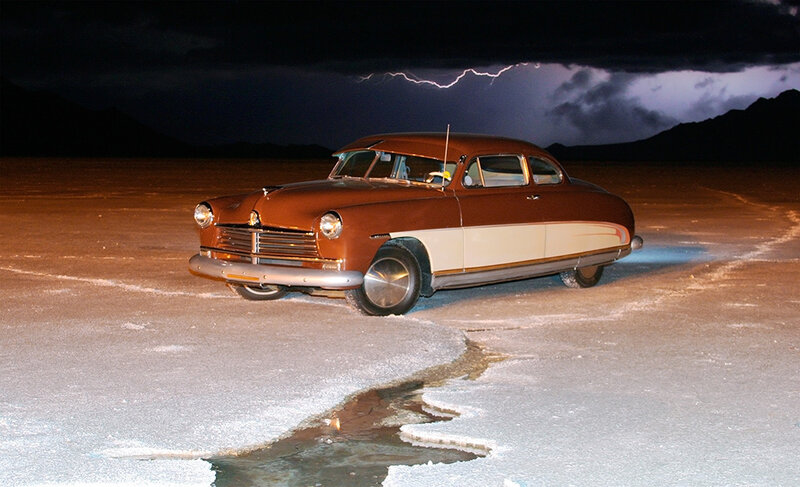 Classic car on salt flat at night