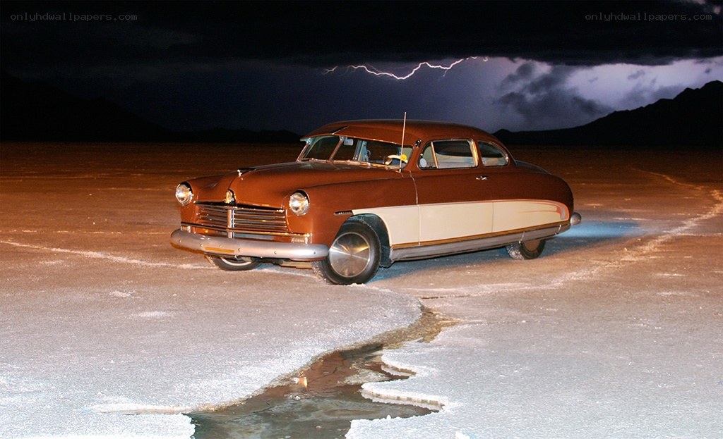 Classic car on salt flat at night