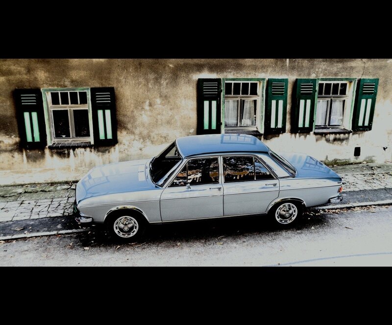 Classic car parked by old building