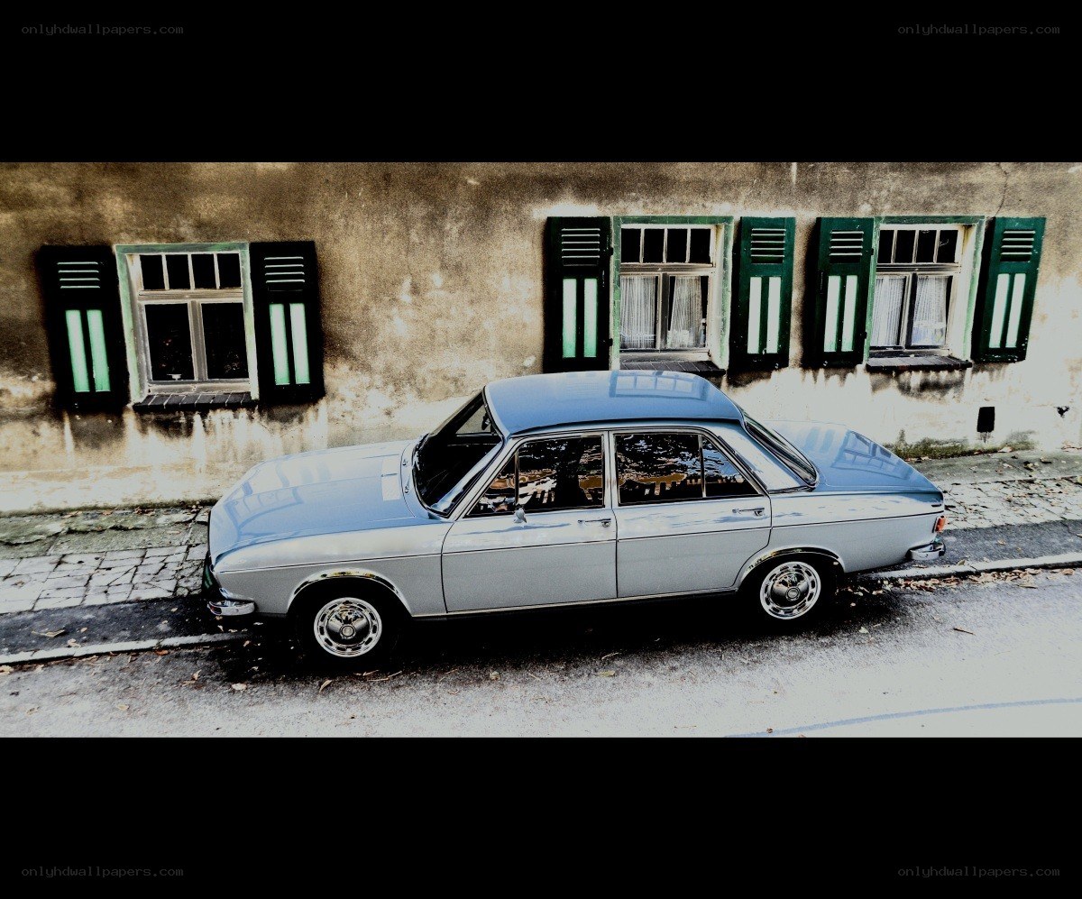 Classic car parked by old building