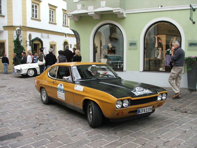 Classic cars on display in a town square