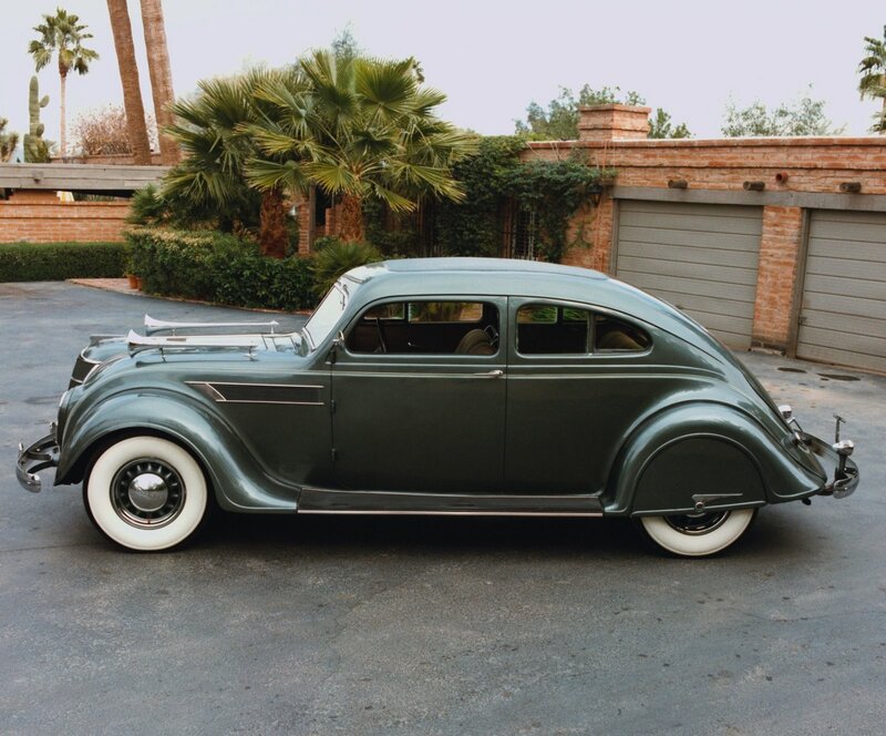 Classic green car in driveway