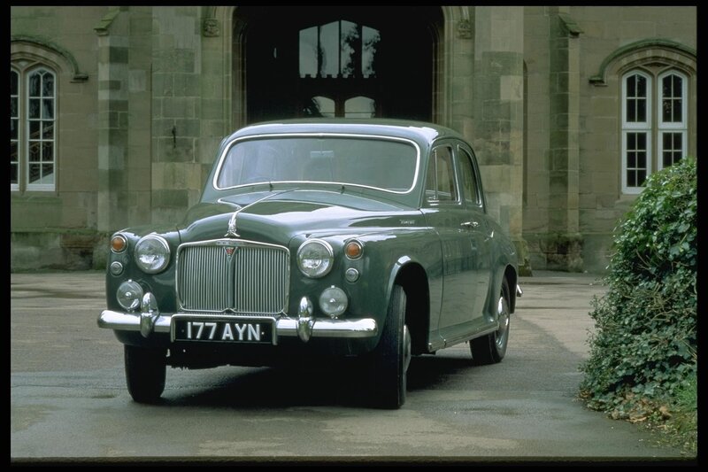Classic green car in front of building