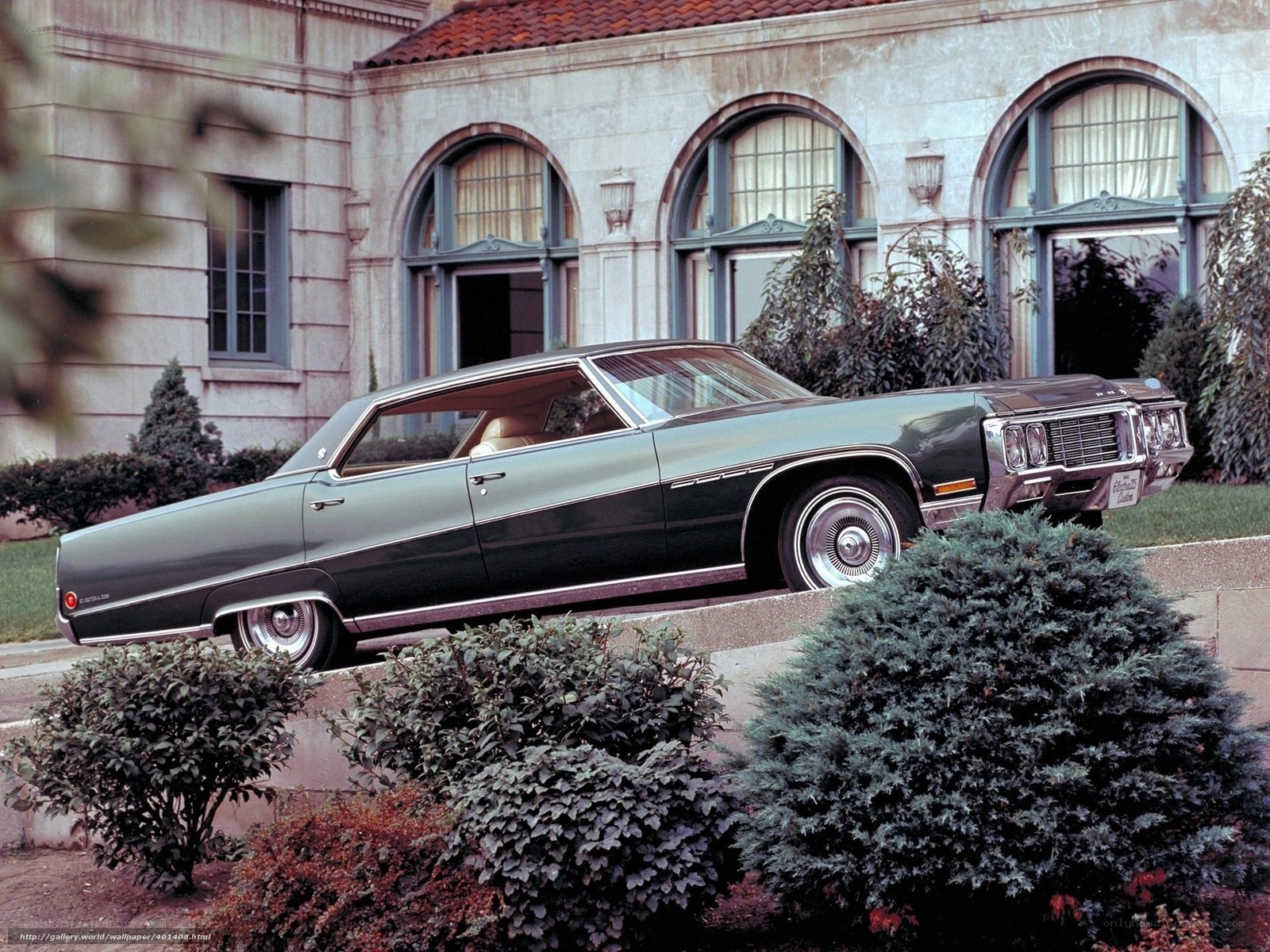 Classic green sedan in front of building