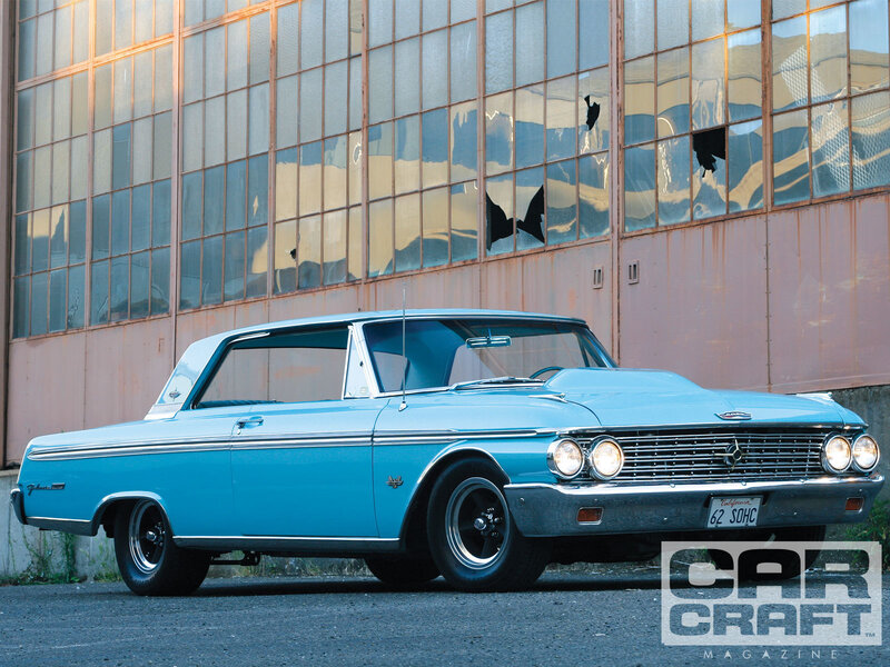 Classic light blue car in front of building