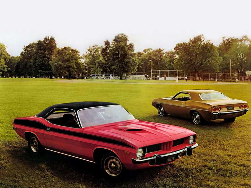 Classic muscle cars on a field