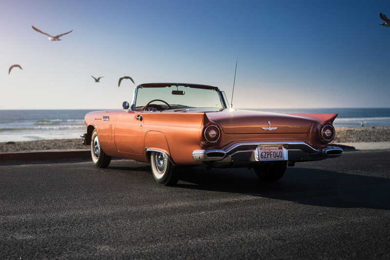 Classic orange convertible by the beach
