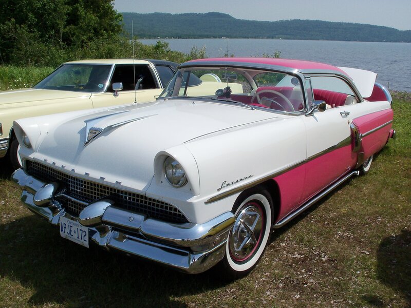 Classic pink and white car by the lake