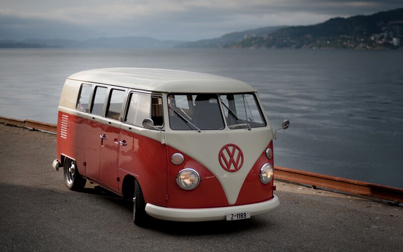 Classic red and white VW bus by the water