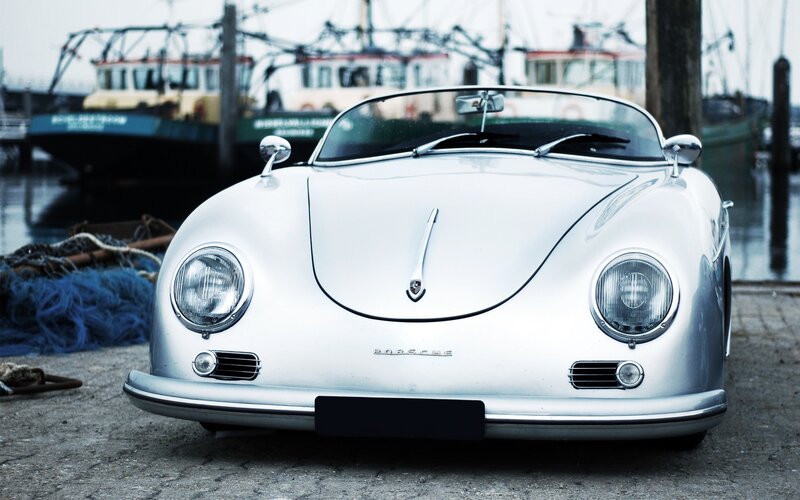 Classic silver Porsche at a harbor