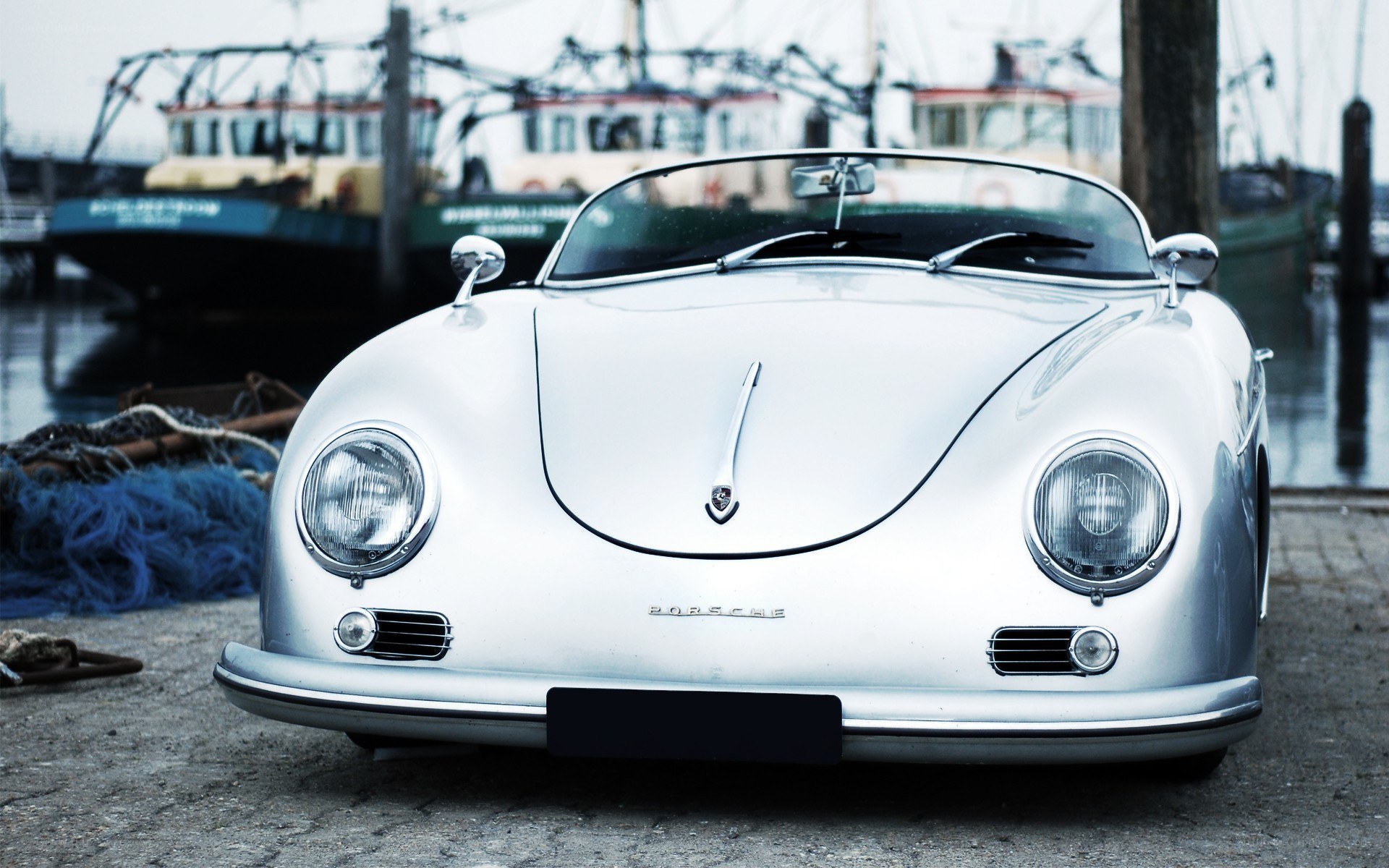 Classic silver Porsche at a harbor