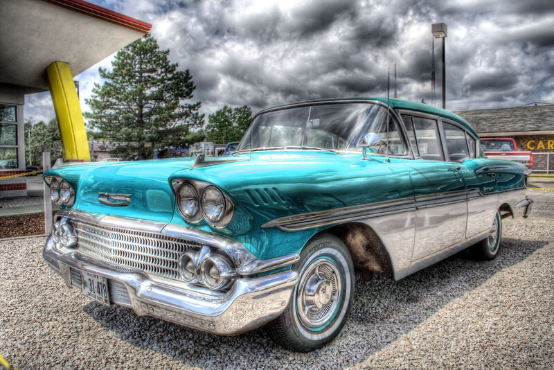 Classic turquoise car at gas station