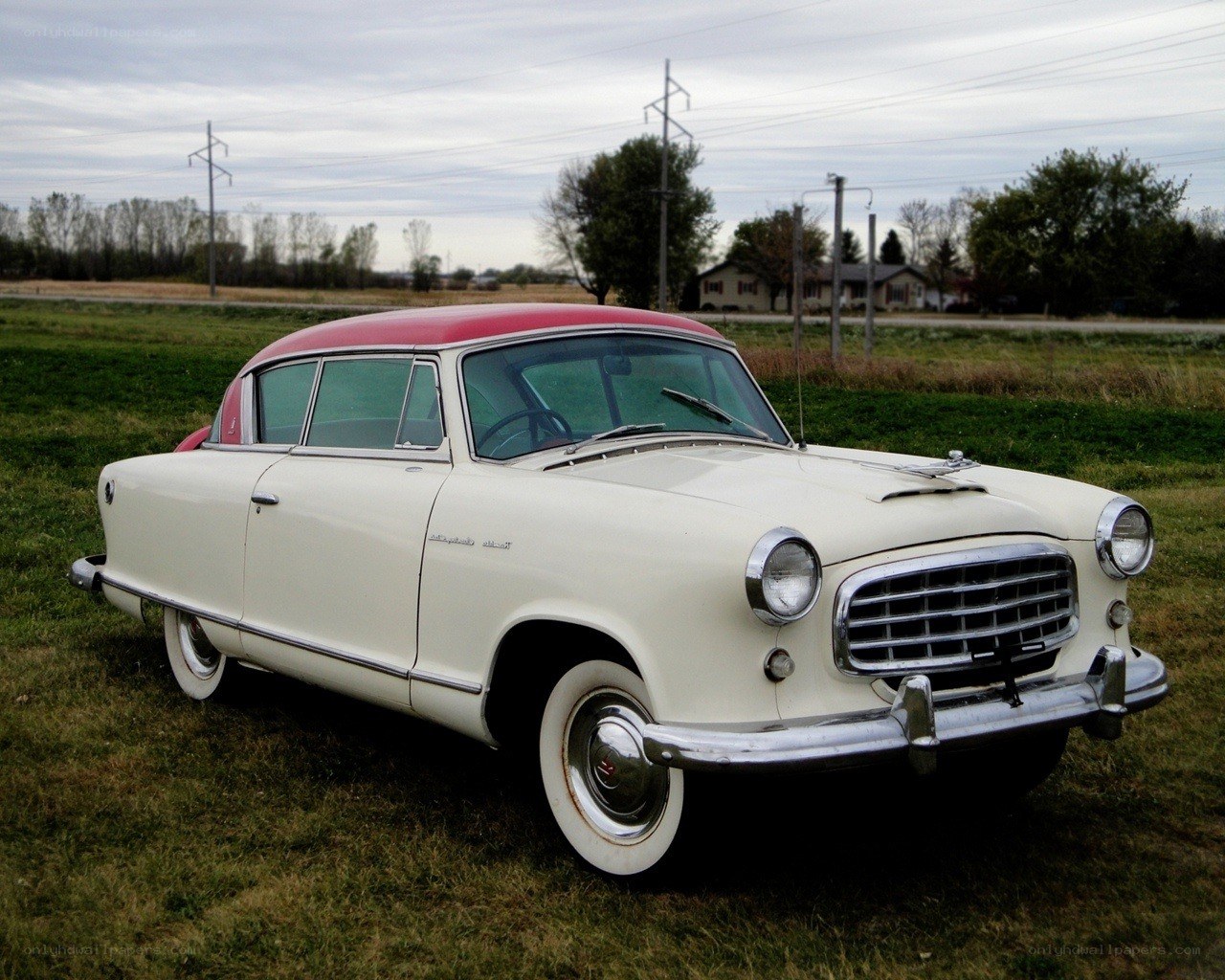 Classic white and red car in field