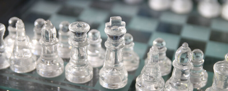 Clear glass chess pieces on board