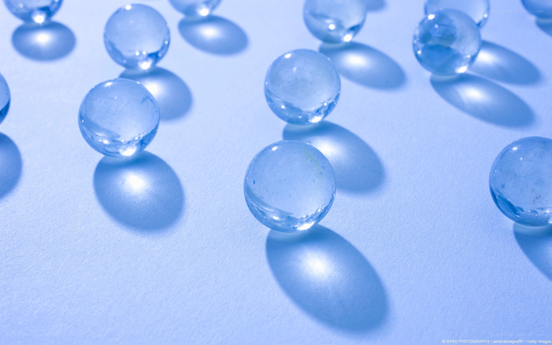 Clear glass marbles on blue surface
