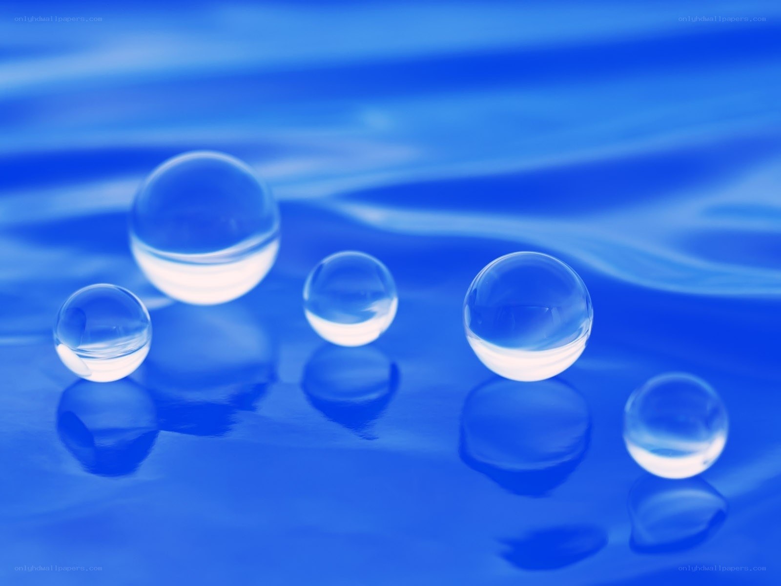 Clear glass spheres on blue surface