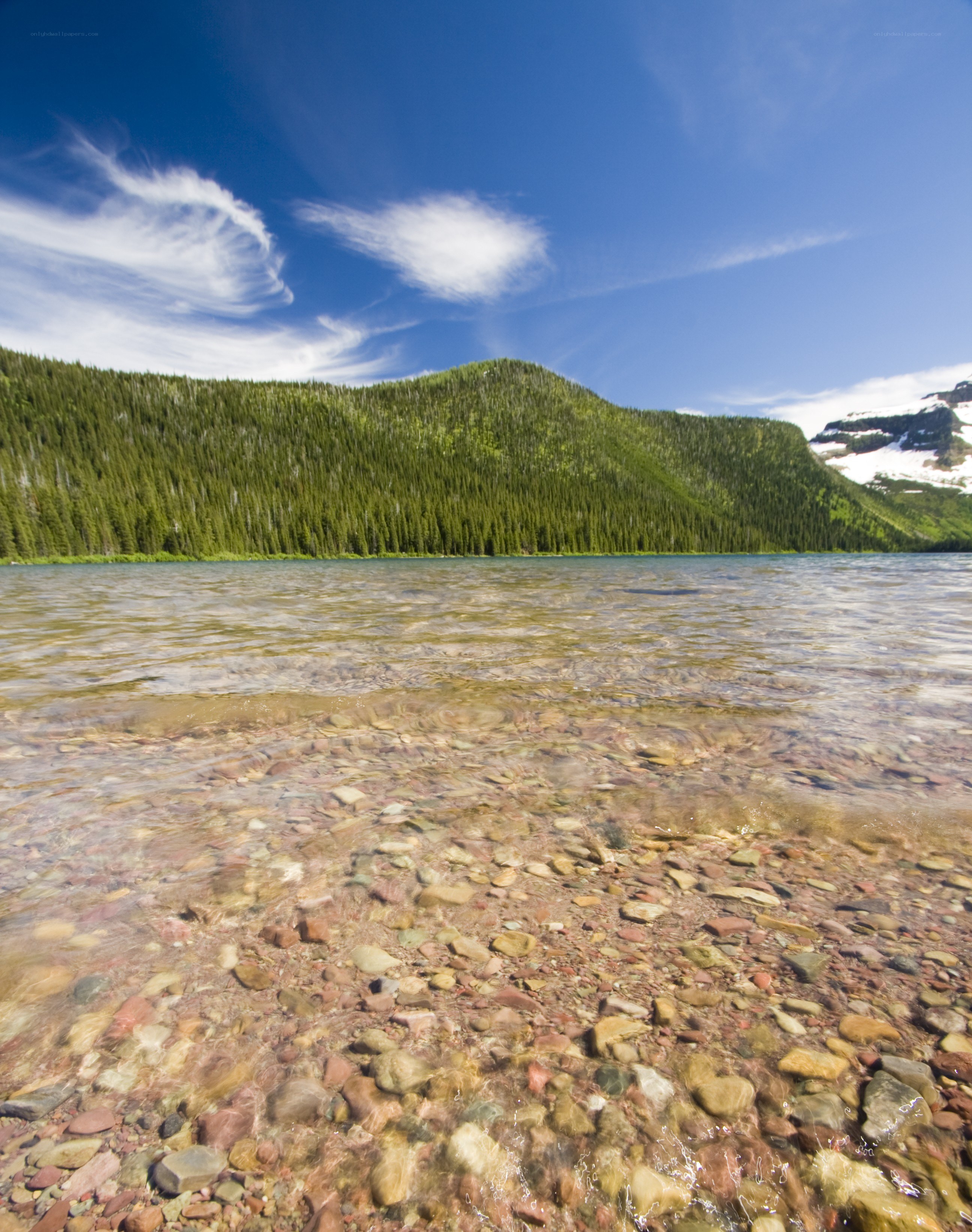 Clear lake with forested hills