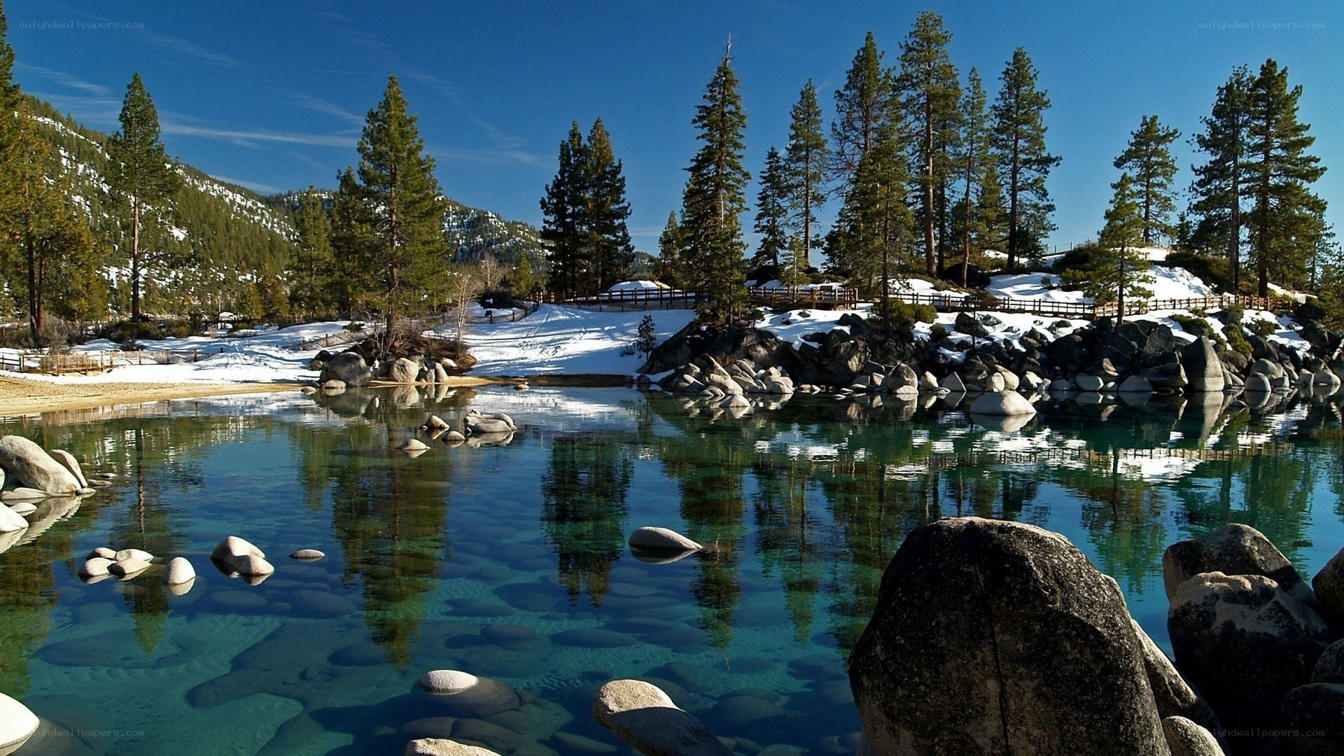 Clear lake with snow and trees