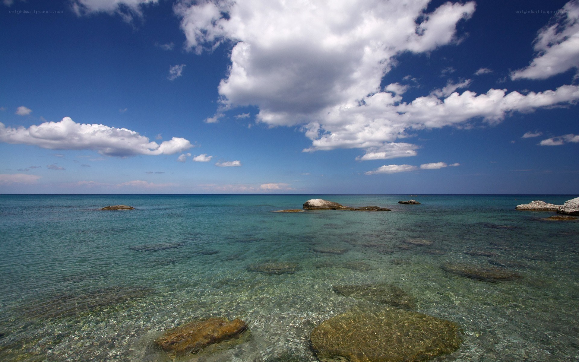 Clear sea with rocks and clouds