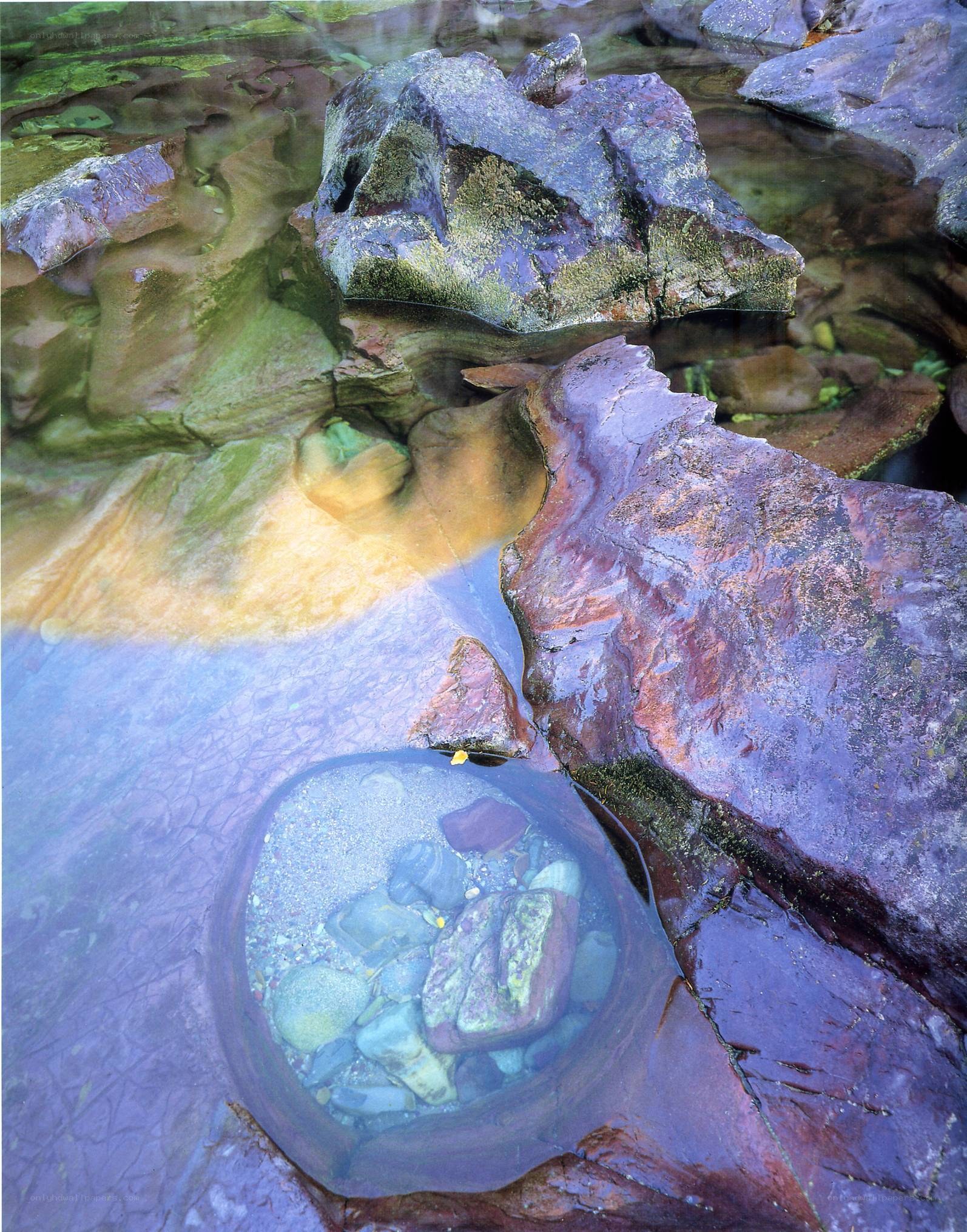 Clear water over colorful rocks