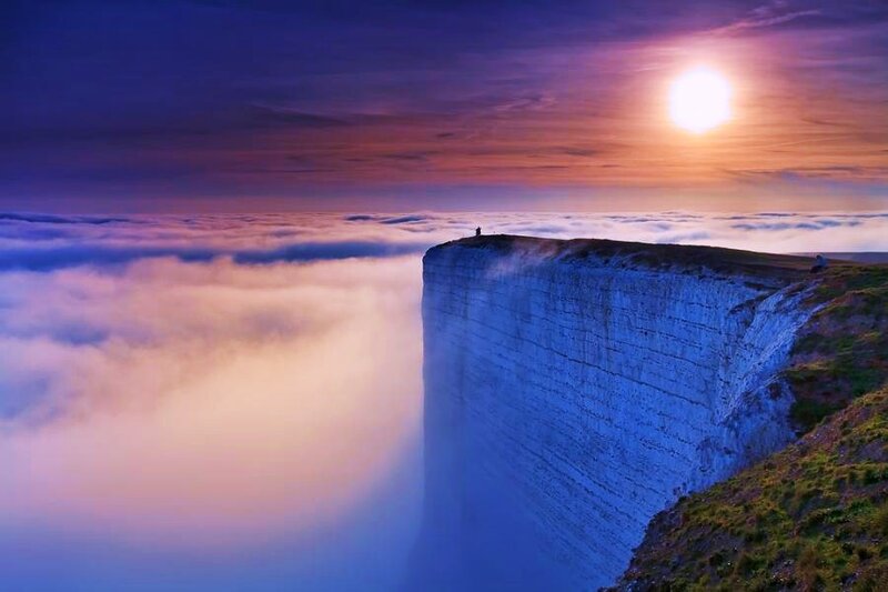 Cliff over clouds at sunset