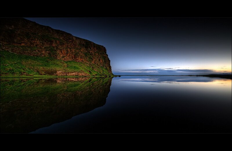 Cliff reflected in calm water