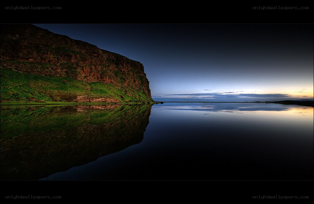 Cliff reflected in calm water