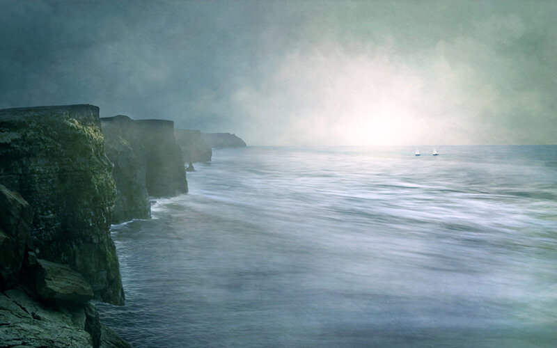 Cliffs and sailboats at sea