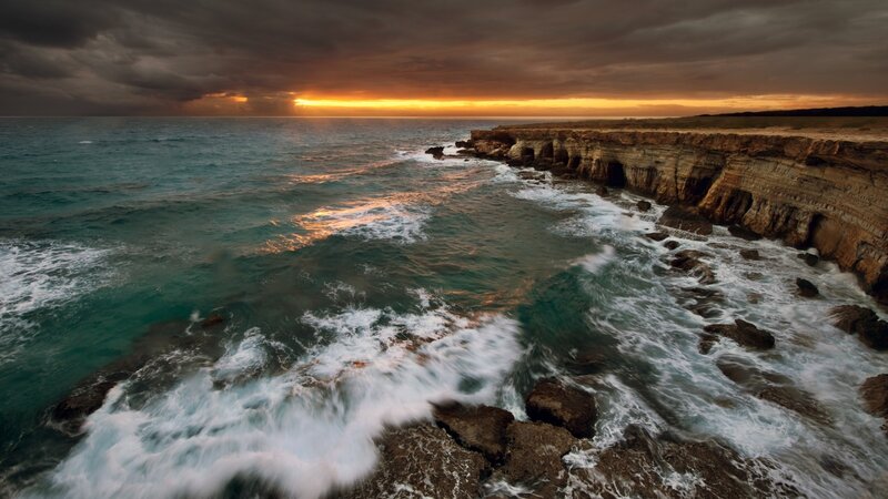 cliffs at sunset with crashing waves