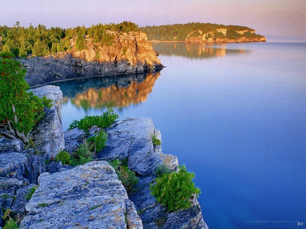 Cliffs over calm lake at dawn