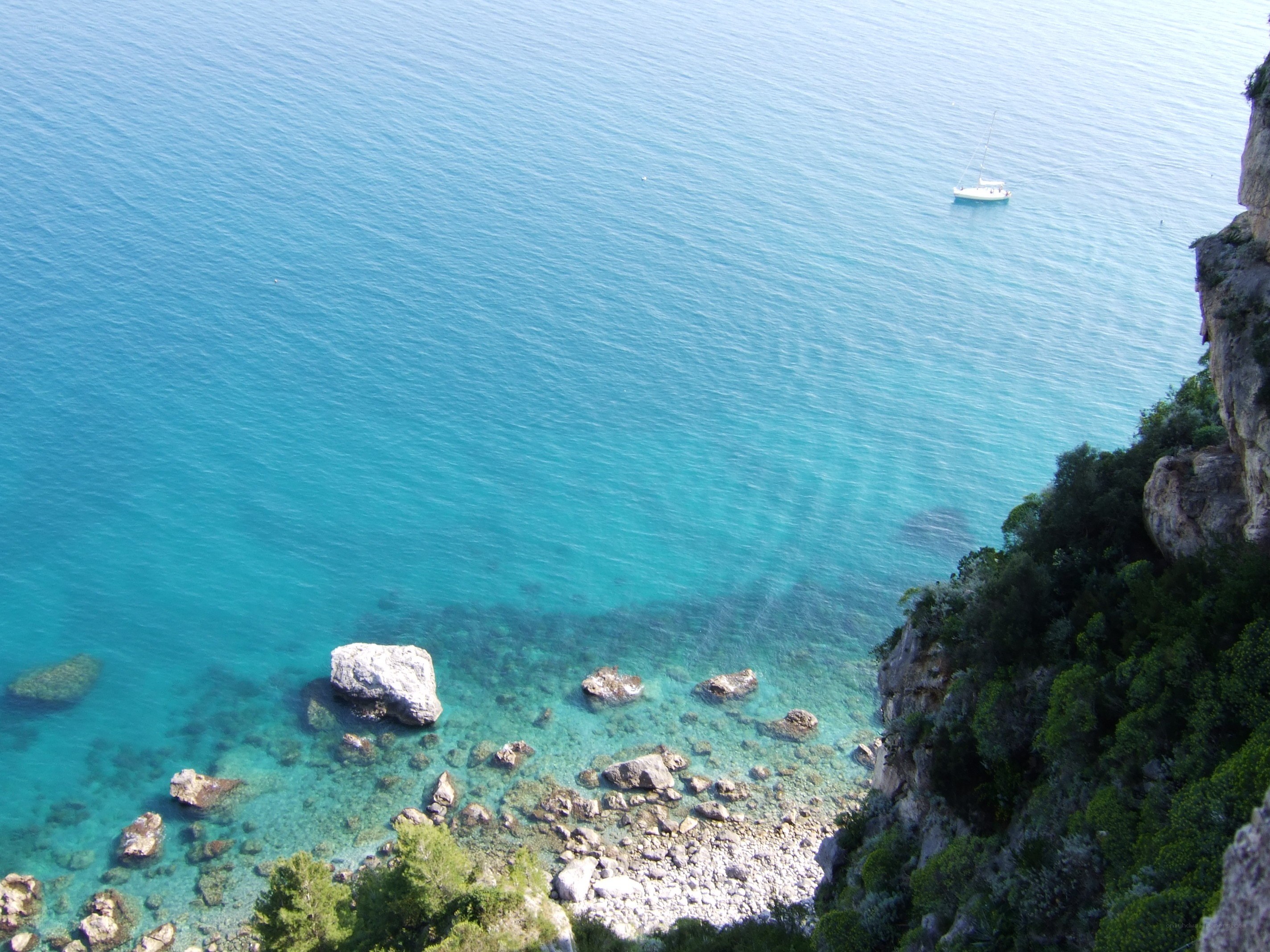 Cliffside bay with sailboat