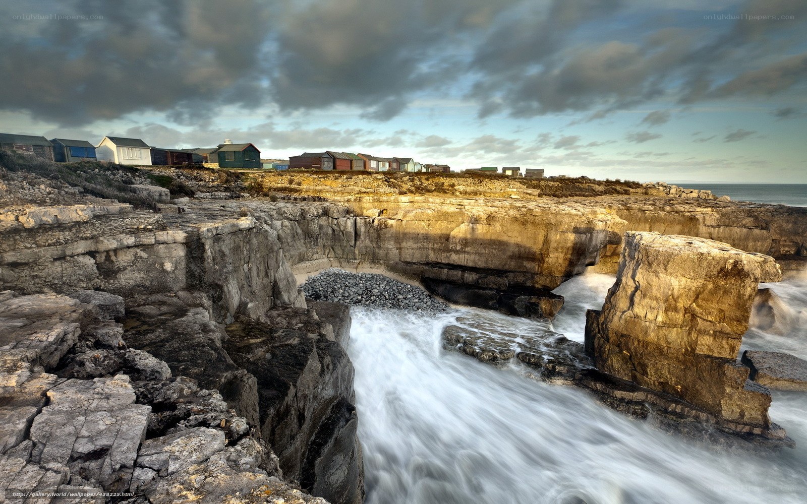 Cliffside beach huts and sea cave