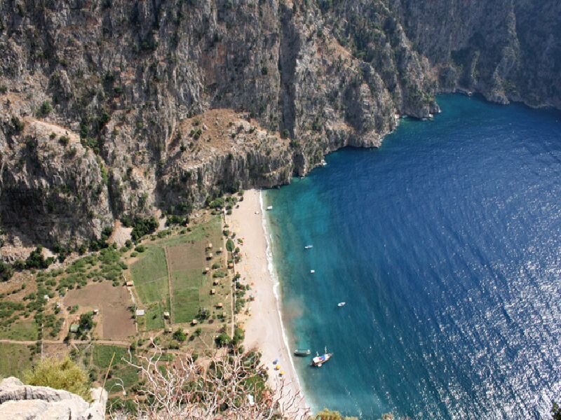 cliffside beach with boats