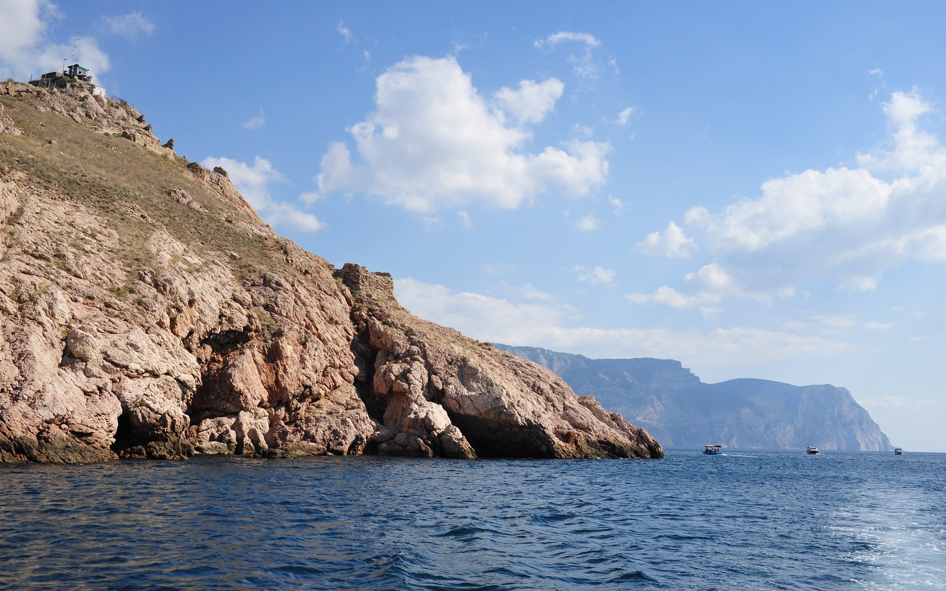 cliffside coast with boats