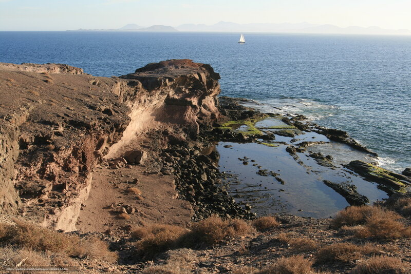 Cliffside coastal view with sailboat