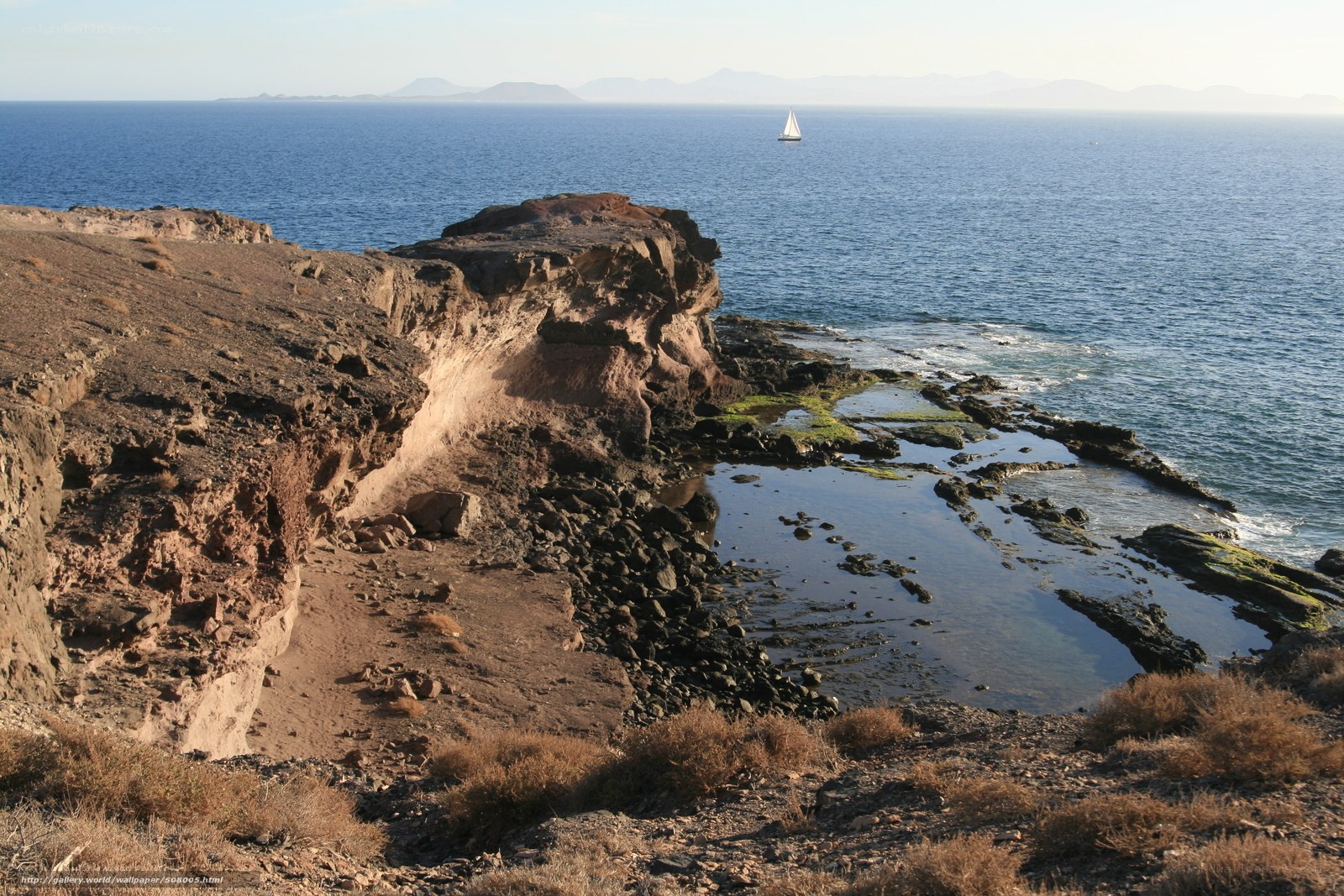 Cliffside coastal view with sailboat