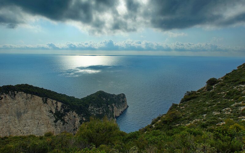 Cliffside Coastline — Blue, Dramatic, Afternoon, Photograph, Ocean, Clouds, Vegetation