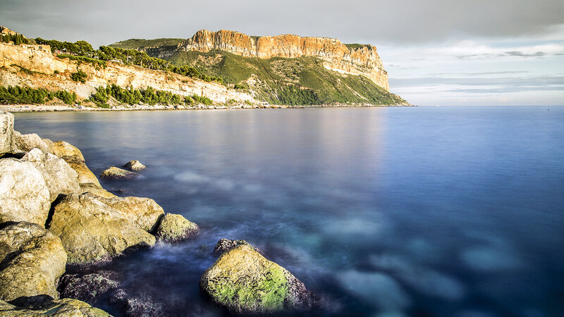 Cliffside Coastline — Blue, Serene, Sunset, Photograph, Rocks