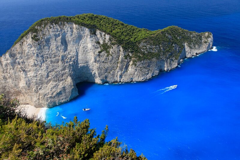 Cliffside Cove with Beach — Blue, Serene, Afternoon, Photograph, Boat