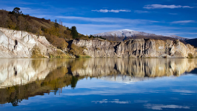 Cliffside lake with mountain reflection