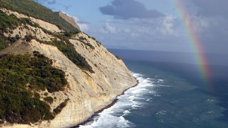 cliffside rainbow over ocean