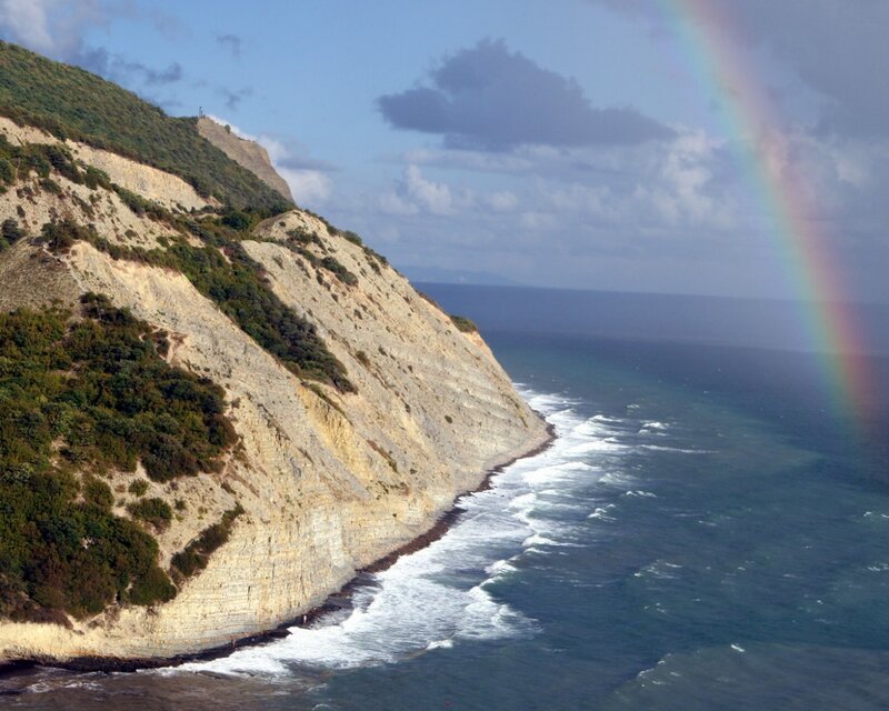 Cliffside rainbow over the sea