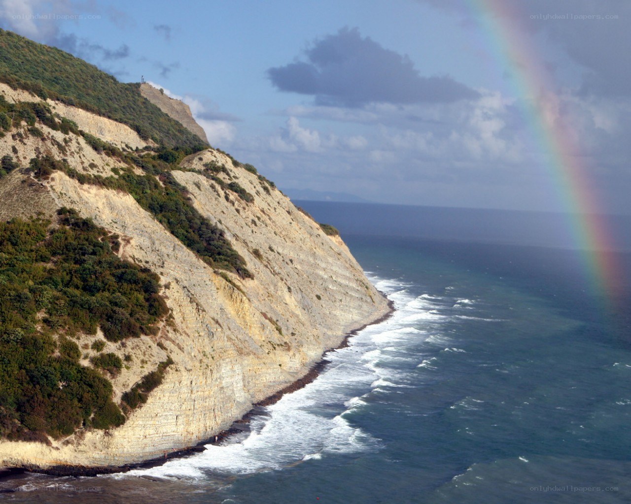 Cliffside rainbow over the sea