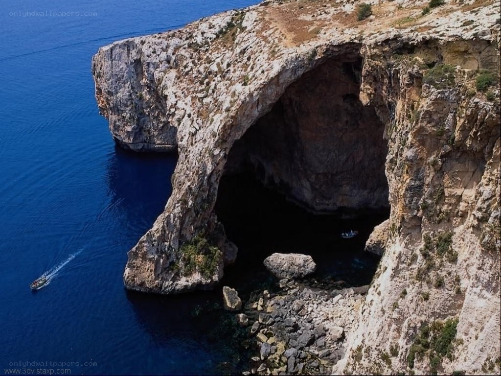 cliffside sea cave with boats