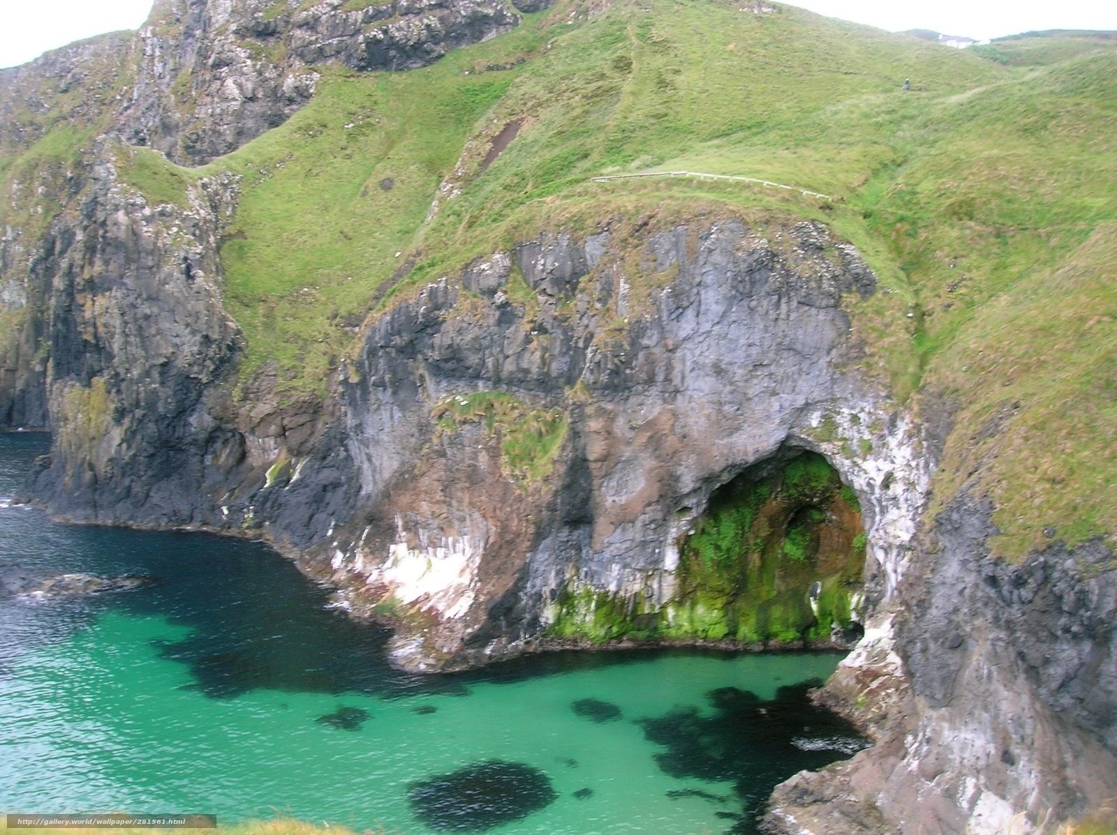 cliffside sea cave with green water