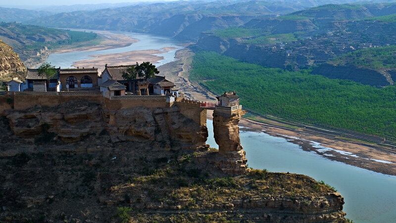 cliffside temple by a river
