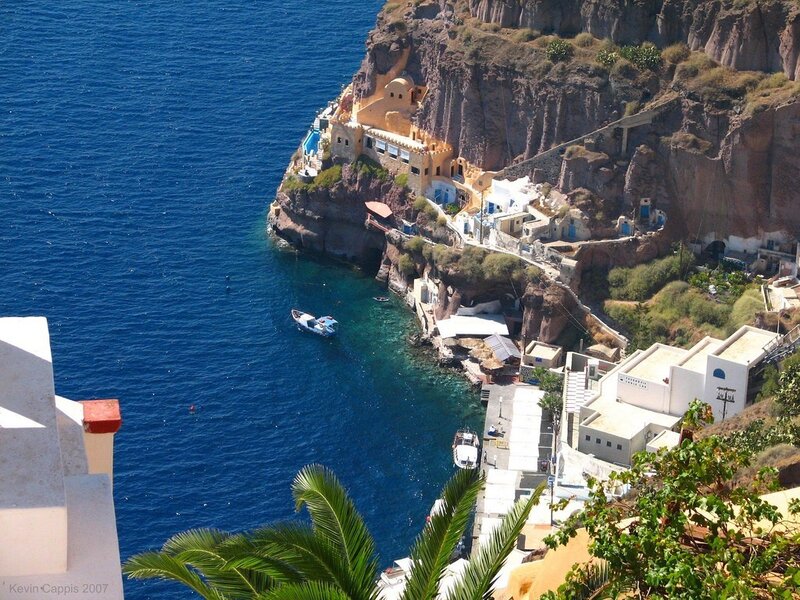 Cliffside Village by Sea — Blue, Serene, Afternoon, Photograph, Buildings, Boat