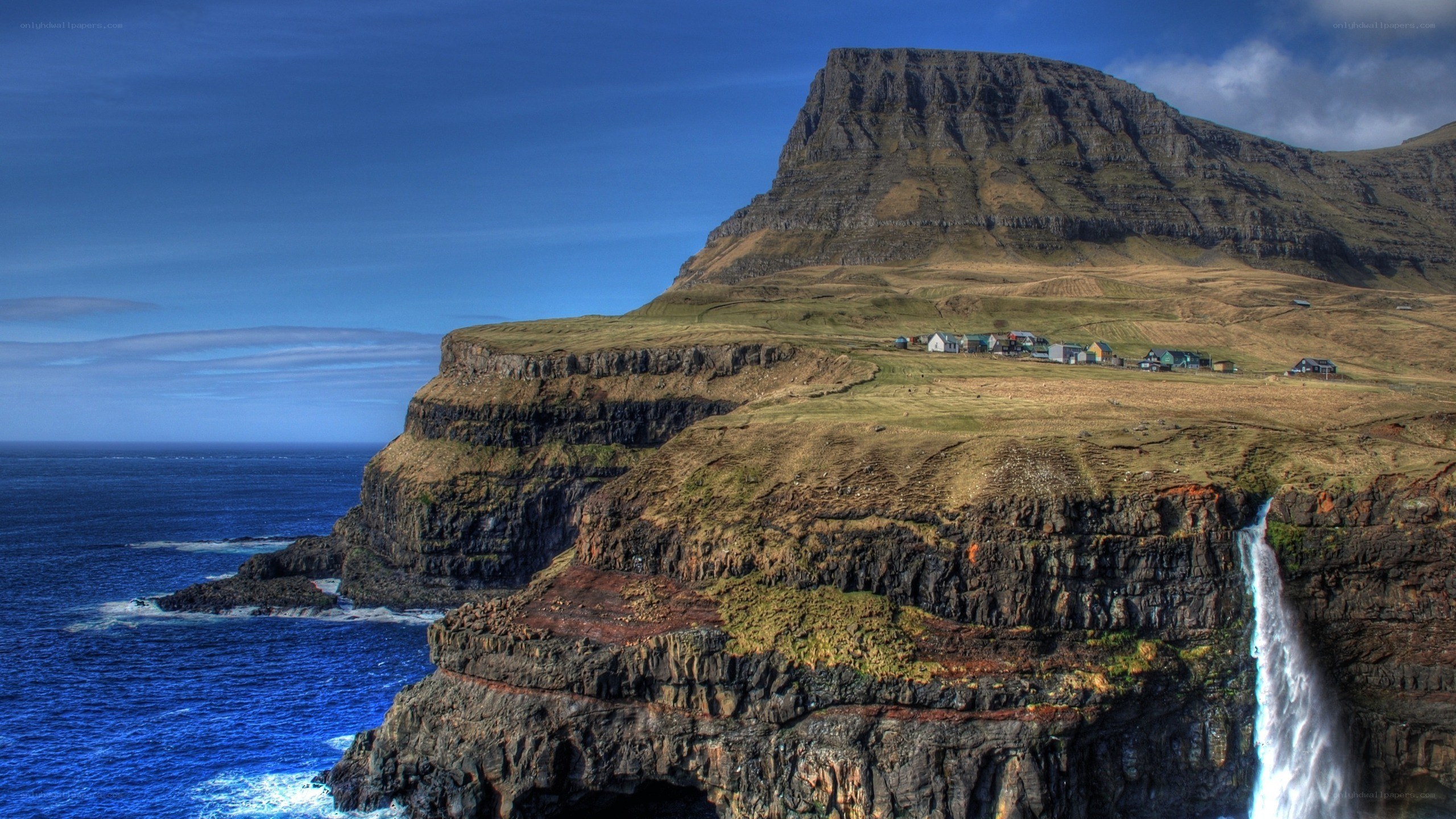 cliffside village with waterfall