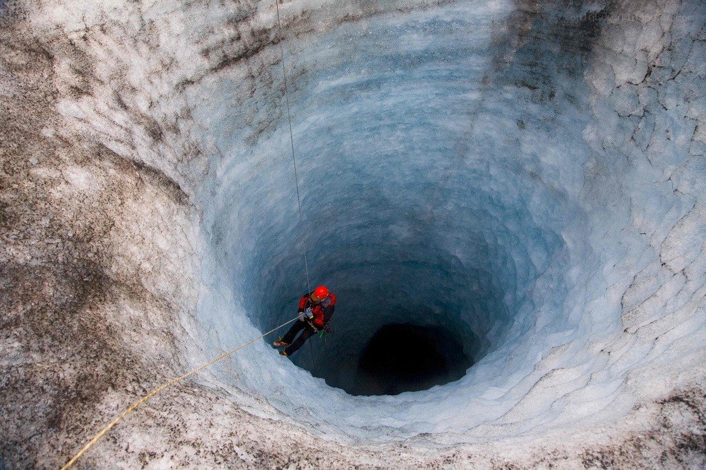 Climber descending into ice cave
