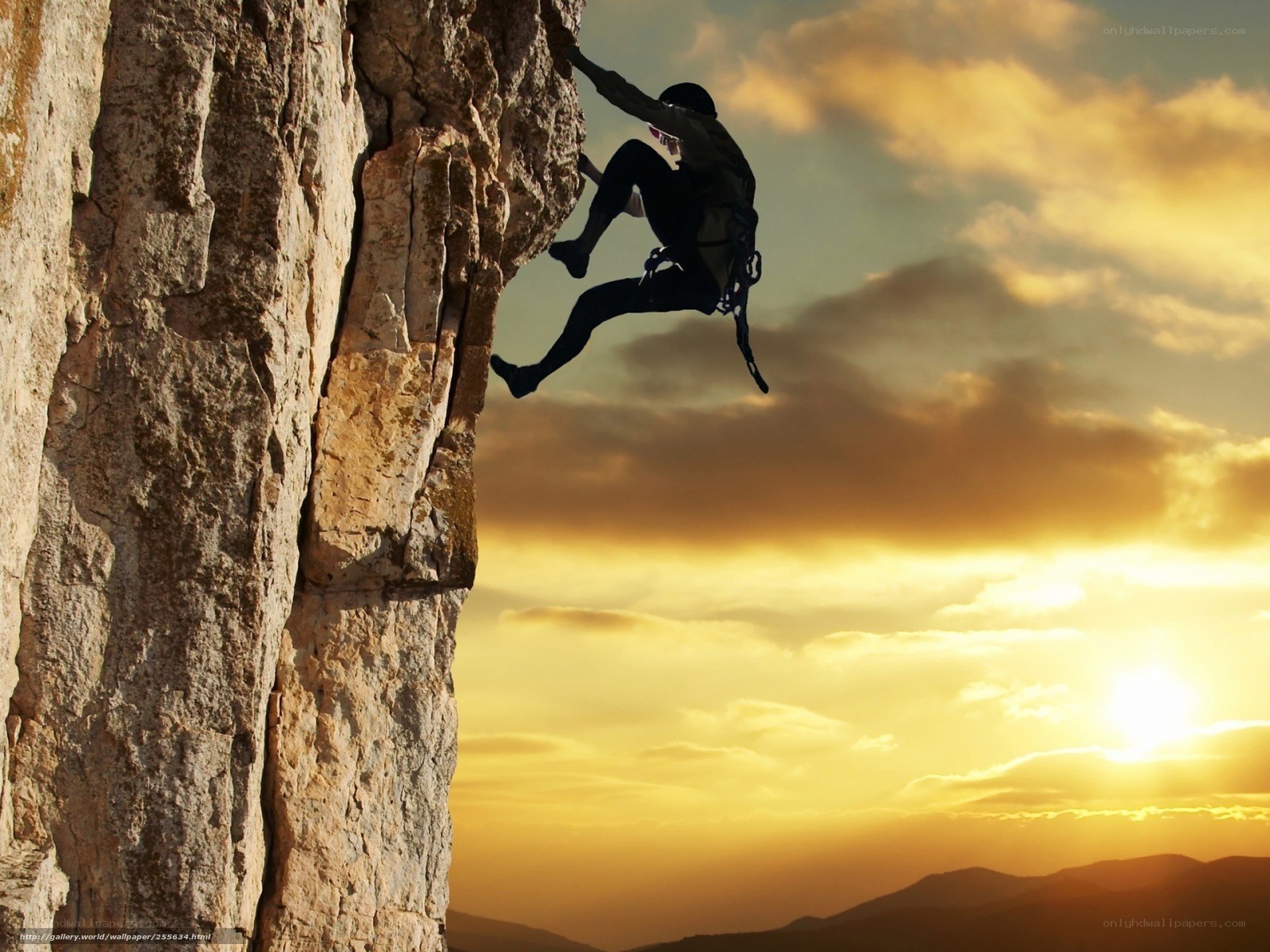 Climber on a cliff at sunset